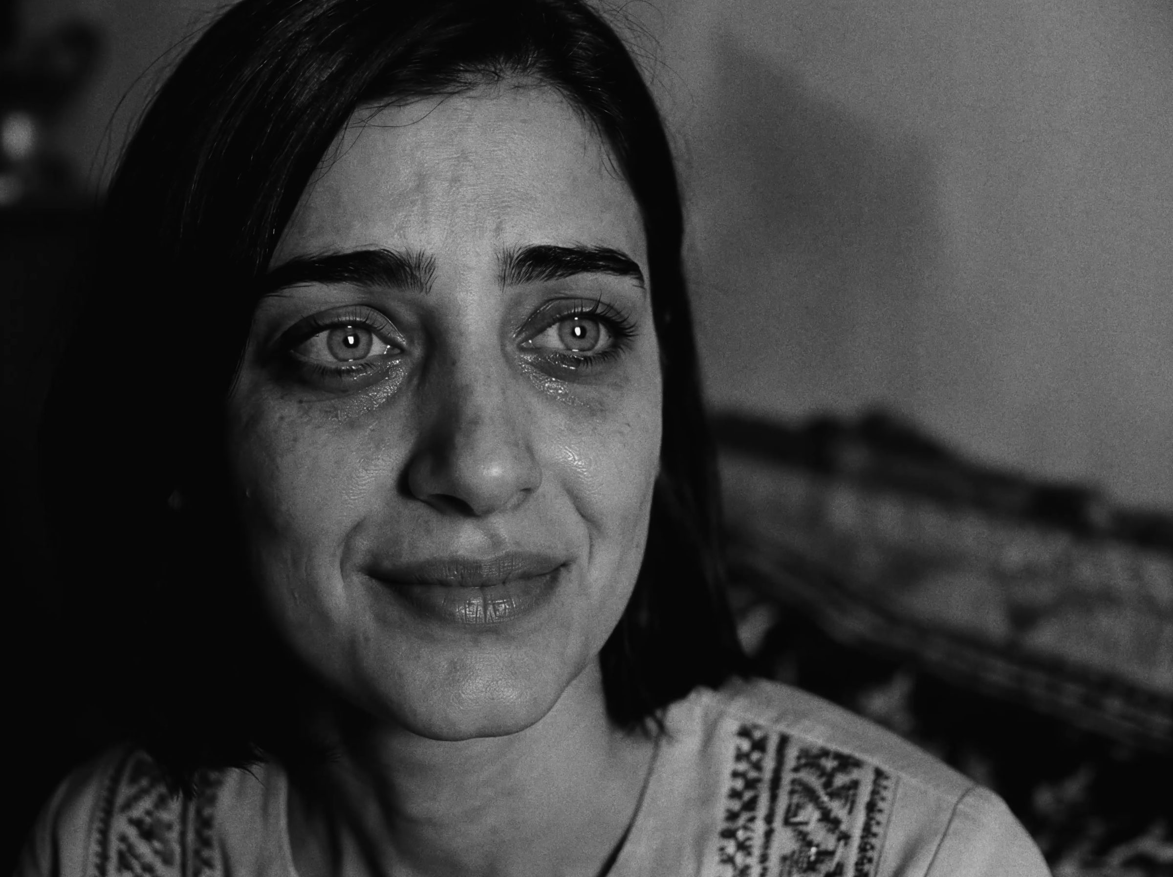 A Palestinian mother, eyes wet, half-smiling.