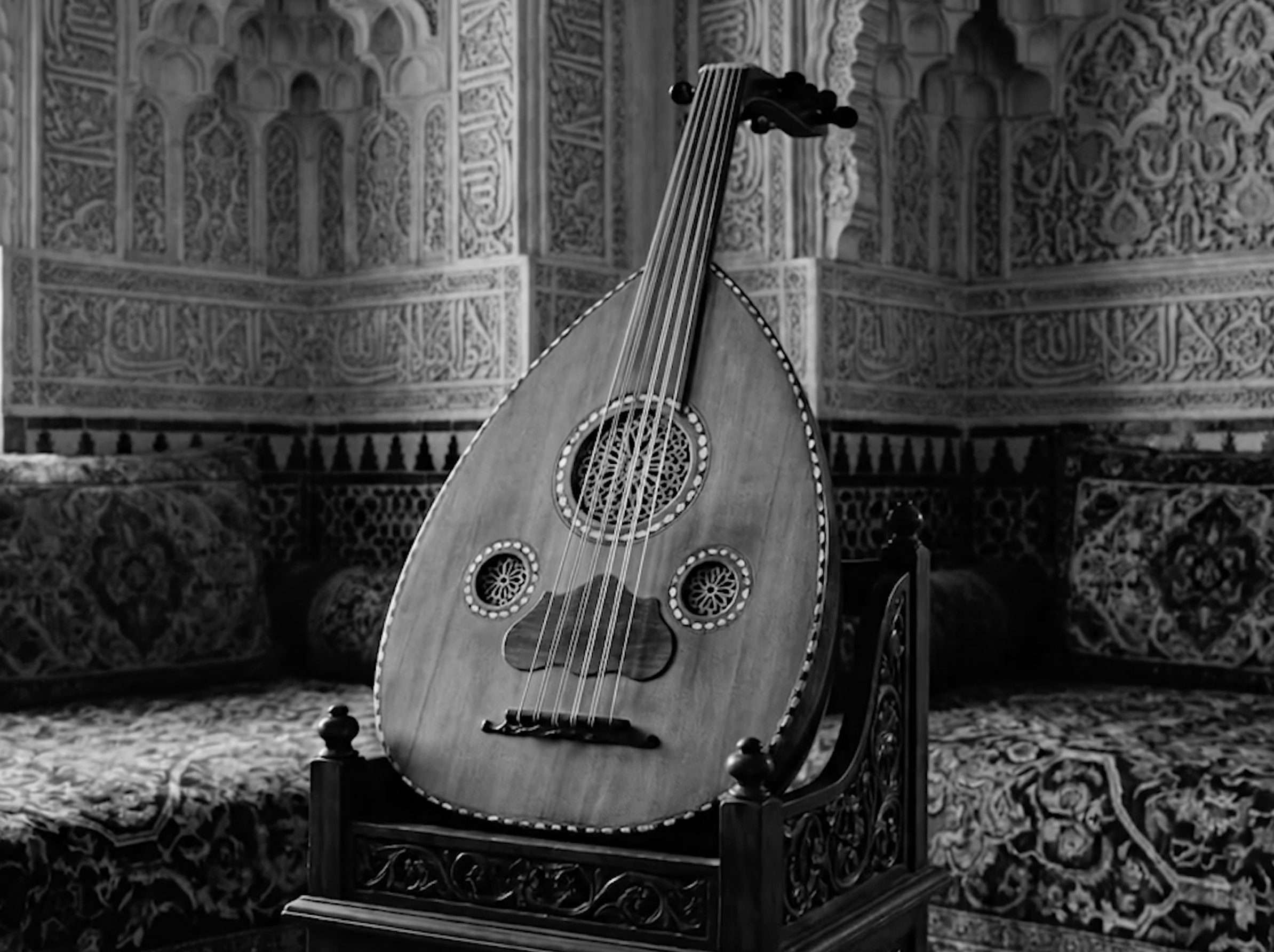 An oud resting before carved plaster walls.